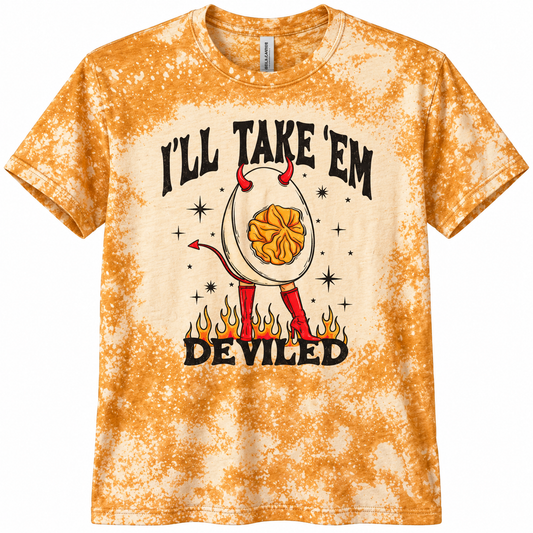 A short-sleeve crewneck t-shirt featuring a golden-yellow acid wash tie-dye pattern. The front has a graphic of a toilet paper egg with devil horns and legs, standing on flames, with the text 'I'LL TAKE 'EM DEVILED' in black.