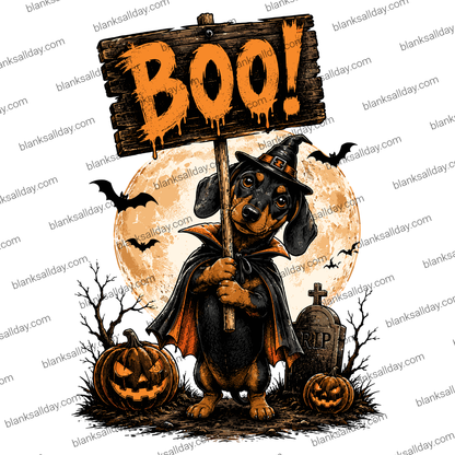 Halloween graphic design featuring a dachshund dressed as a witch holding a wooden sign that says 'BOO!'. The scene includes a full moon, bats, a jack-o'-lantern, a tombstone, and bare branches on a white background.