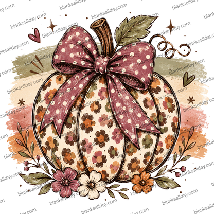 A decorative autumn pumpkin illustration with a large dusty rose bow covered in white polka dots, surrounded by floral details and watercolor-style fall washes on a white background.