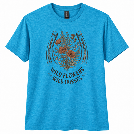 A heather blue short-sleeve crewneck t-shirt featuring a graphic of a horseshoe with wildflowers and the text 'WILD FLOWERS WILD HORSES' printed on the front.